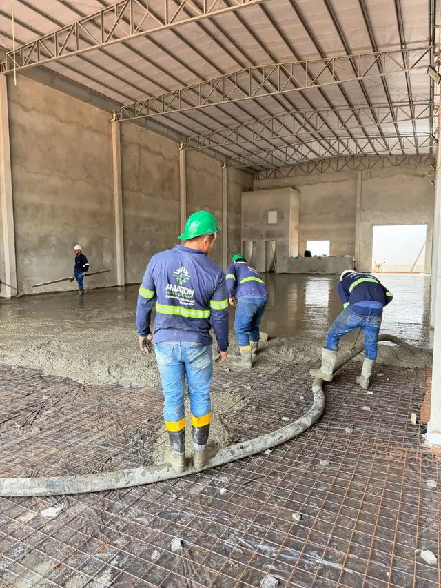 Equipe própria distribuindo o concreto bombeado sobre a malha.